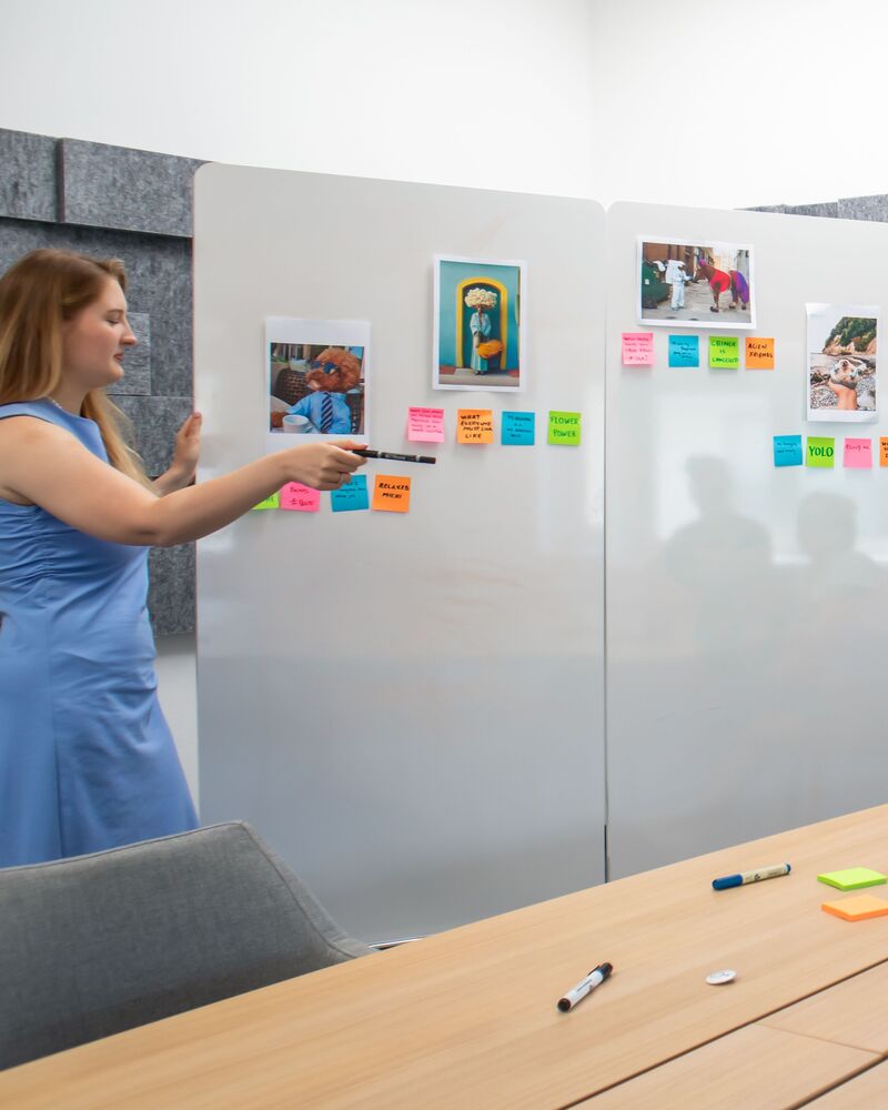 Animation d'un atelier participatif devant un tableau blanc couvert de post-it