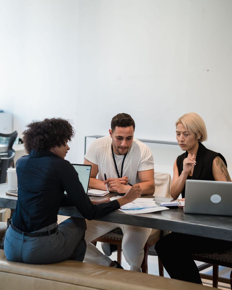 Trois collaborateurs travaillant ensemble autour d'une table